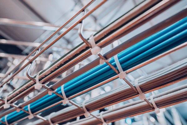 Metal wire basket containment efficiently holding and organizing several electrical cables.